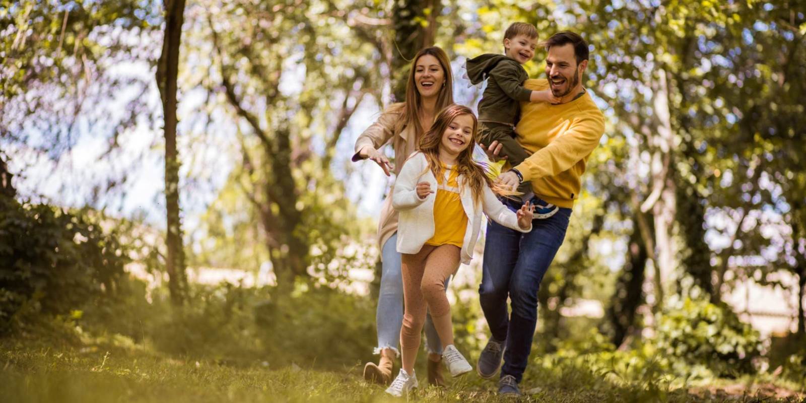 Familie auf der Wiese unter den Bäumen