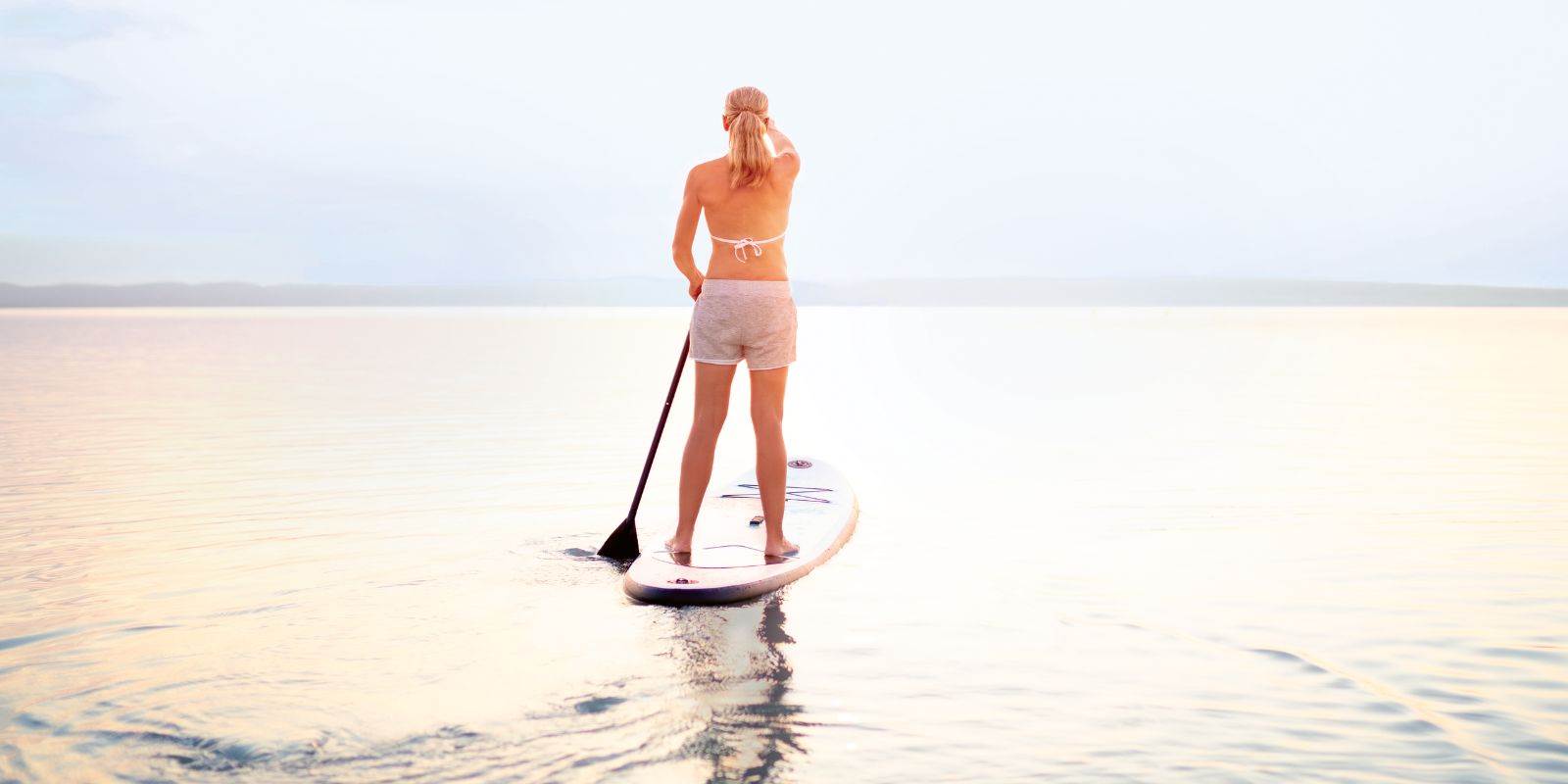 frau auf stand up padel auf see