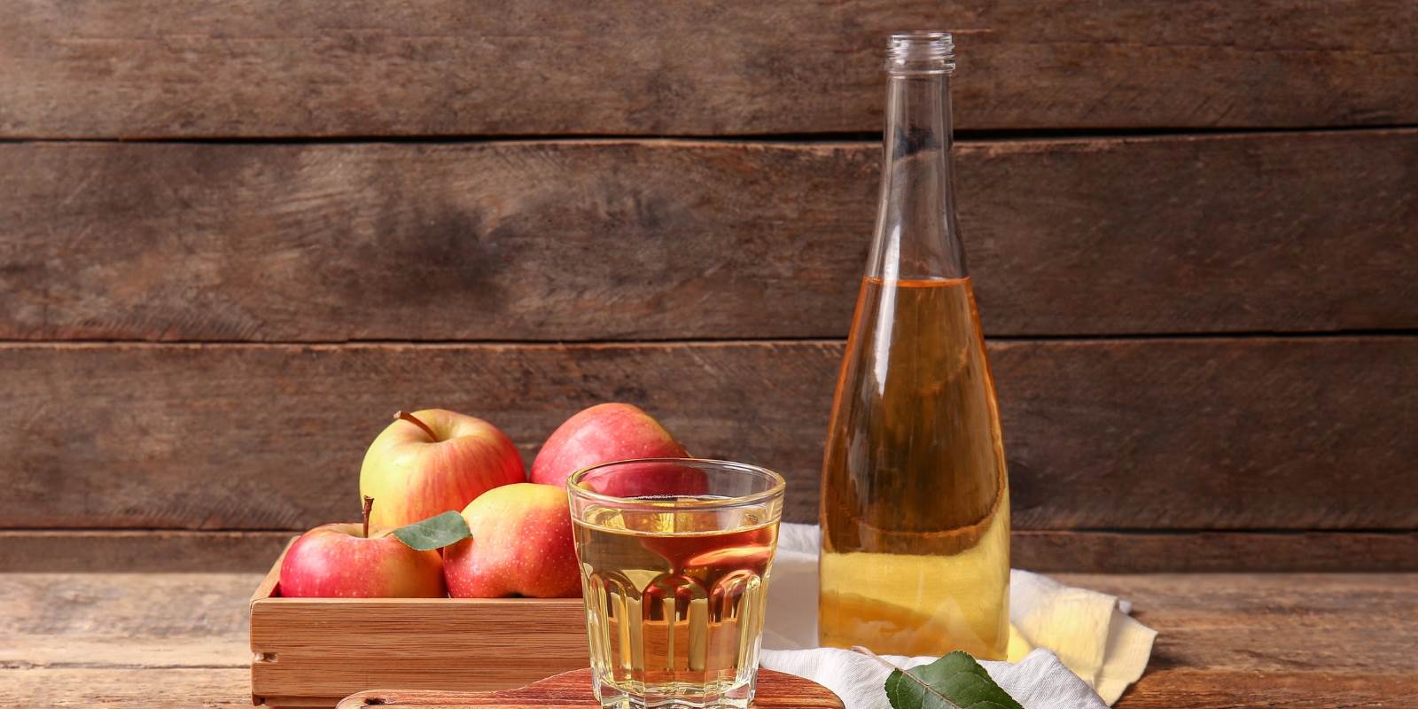 Flasche Essig mit Apfel auf Holztisch